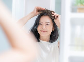 かつらを装着する女性