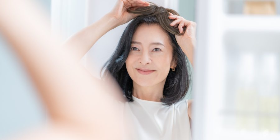 かつらを装着する女性