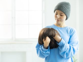 医療用ウィッグを手に持つ女性